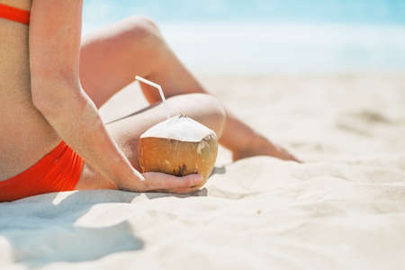 Closeup on young woman sitting with coconutの写真素材