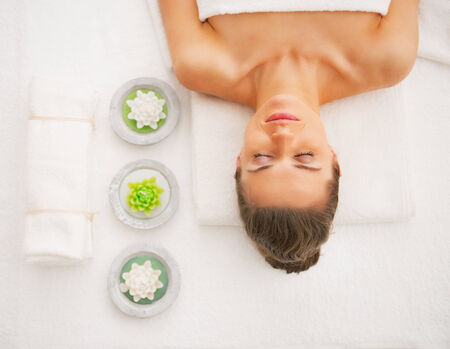 Portrait of young woman laying on massage tableの写真素材