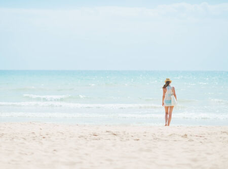 Young woman standing on beach. rear viewの写真素材