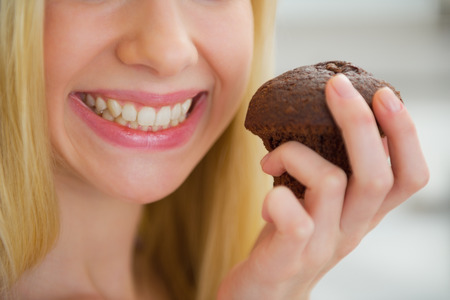 Closeup on young woman holding chocolate muffinの写真素材