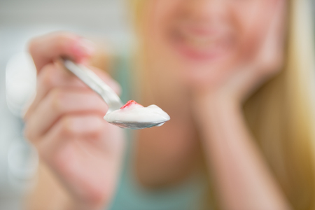 Closeup on young woman giving spoon with yogurtの写真素材