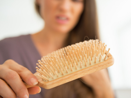 Closeup on stressed young woman looking on hair combの写真素材