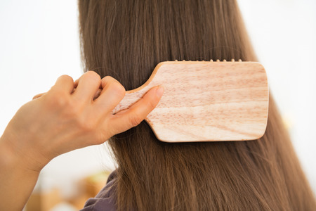 Closeup on young woman combing hairの写真素材