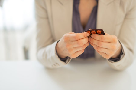 Closeup on business woman taking pill from blister packの写真素材