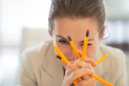 Portrait of business woman holding pencilsの写真素材