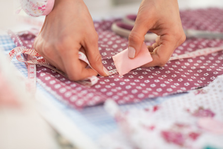 Closeup on seamstress making marks on fabricの写真素材