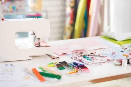 Closeup on table of seamstress with scissors threads and fabric