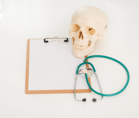 Closeup on human skull stethoscope and clipboardの写真素材