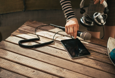 Closeup on young woman with headphones and microphone using tablet pc