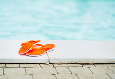 Closeup on sandals laying near swimming pool