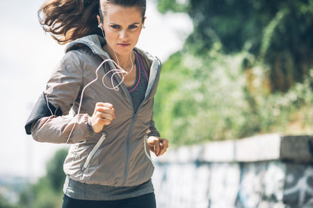 Fitness young woman jogging in the city park