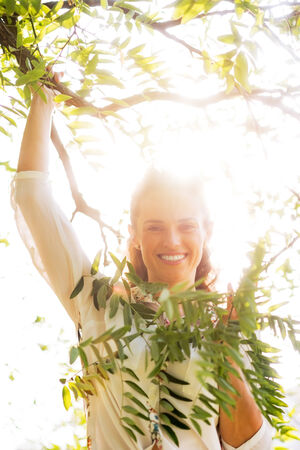 Portrait of smiling young woman in foliageの写真素材