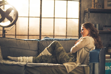 Young woman sitting in loft apartmentの写真素材
