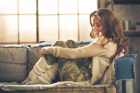 Relaxed young woman sitting in loft apartmentの写真素材