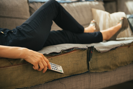 Closeup on young woman watching tv in loft apartmentの写真素材
