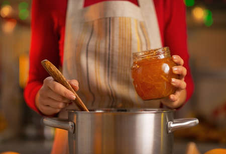 Closeup on young housewife making orange jamの写真素材