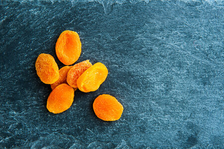 Closeup on dried apricots on stone substrateの写真素材
