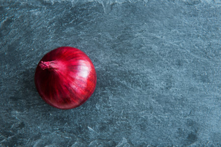 Closeup on red onion on stone substrateの写真素材