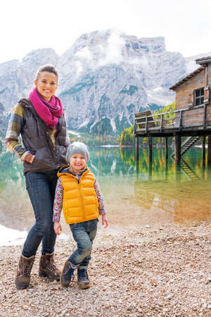 Full length portrait of happy mother and baby on lake braies in south tyrol, italyの写真素材