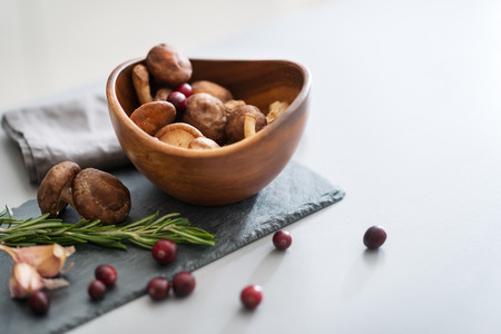 Closeup on mushrooms lingonberries and rosmarinus on tableの写真素材