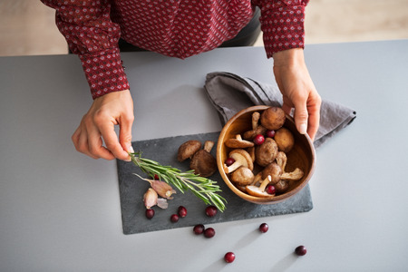 Closeup on young housewife cooking mushroomsの写真素材