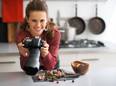 Portrait of happy female food photographer checking photos in cameraの写真素材