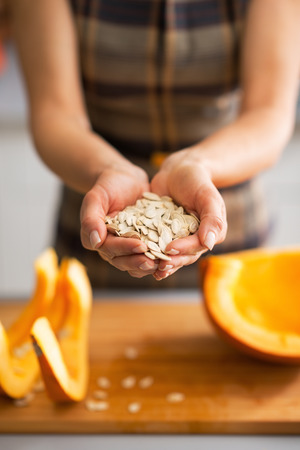 Closeup on young housewife showing pumpkin seedsの写真素材