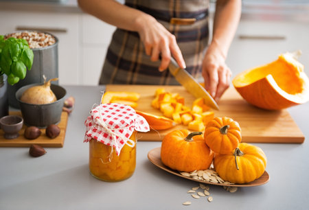 Closeup on young housewife cutting pumpkin for picklingの写真素材