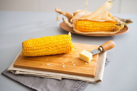 Closeup on boiled corn and butter on cutting boardの写真素材