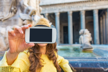 Closeup on young woman making selfie near fountain of the pantheon in rome, italyの写真素材