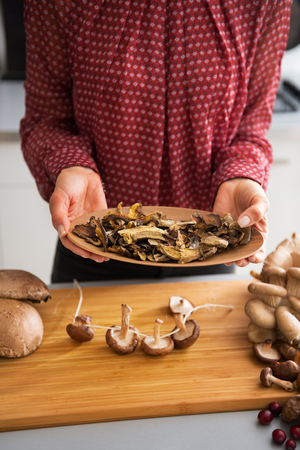 Closeup on young housewife showing dried mushroomsの写真素材