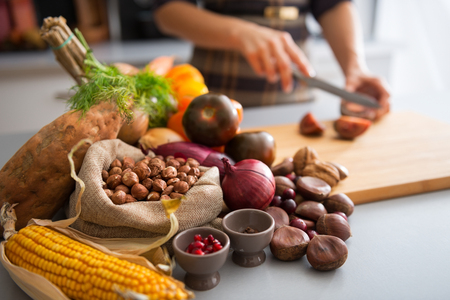 Closeup on vegetables and young housewife cutting cherokee purple tomatoの写真素材