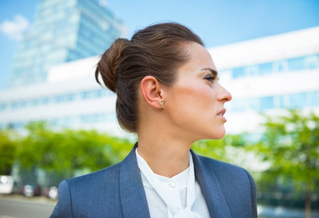 Into the ultra-modern business trends. Portrait of business woman in modern office district looking asideの写真素材