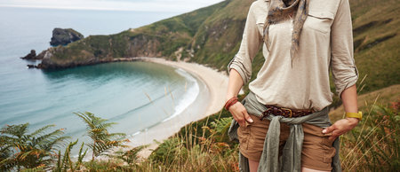 Into the wild in Spain. active woman hiker looking into the distance in front of ocean view...