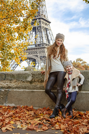 Autumn getaways in Paris with family. Full length portrait of happy mother and child travellers on embankment near Eiffel tower in Paris, Franceの写真素材