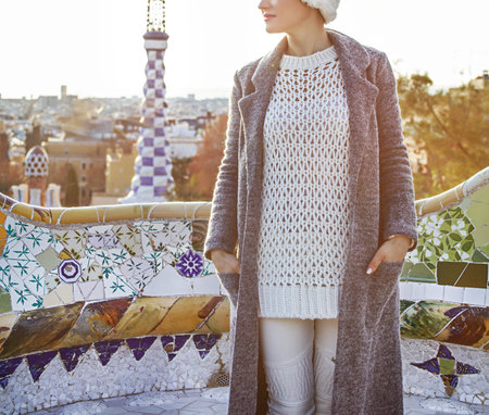 Winter wonderland in Barcelona at Christmas. modern woman in a Santa hat at Guell Park in Barcelona, Spain looking asideの写真素材