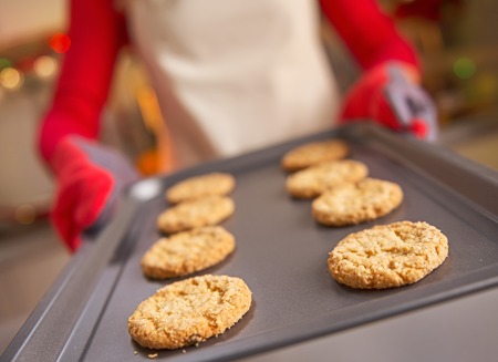 Closeup on pan with christmas cookies in hand of housewifeの写真素材