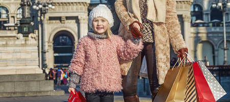 Rediscovering things everybody love in Milan. Full length portrait of happy elegant mother and daughter travellers with shopping bags near Galleria Vittorio Emanuele II in Milan, Italyの写真素材