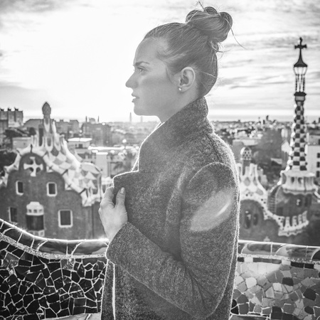 Barcelona signature style. modern tourist woman in coat at Guell Park in Barcelona, Spain looking into the distanceの写真素材