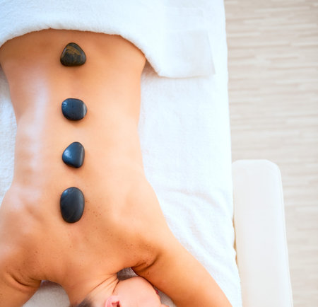 Young woman receiving hot stone massageの写真素材