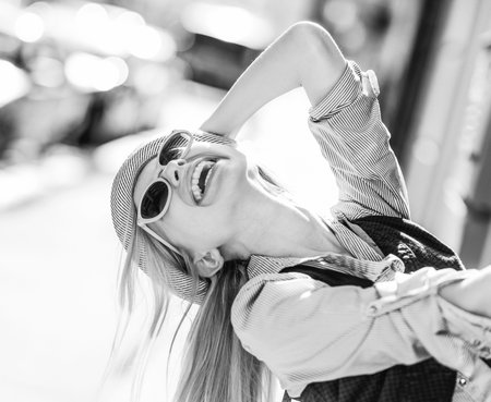Happy hipster girl having fun on city street