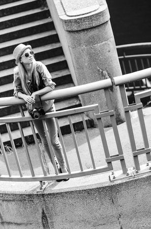 Hipster girl standing on stairs in cityの写真素材