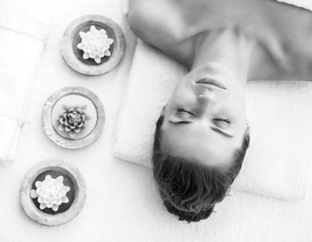 Portrait of young woman laying on massage table