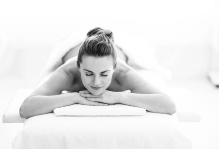 Relaxed young woman laying on massage tableの写真素材