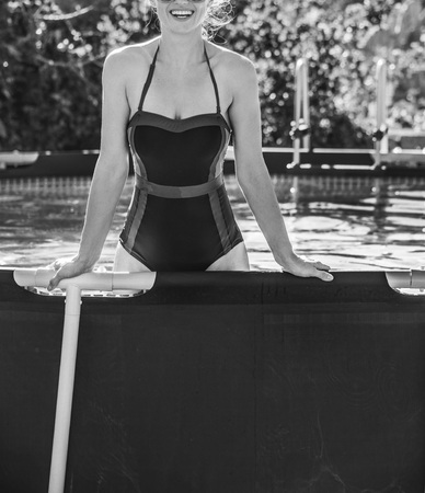 Fun weekend alfresco. Closeup on happy active woman in blue beachwear in the swimming pool in sunglassesの写真素材