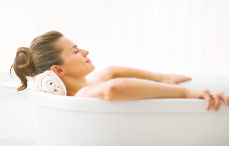 Portrait of young woman relaxing in bathtubの写真素材