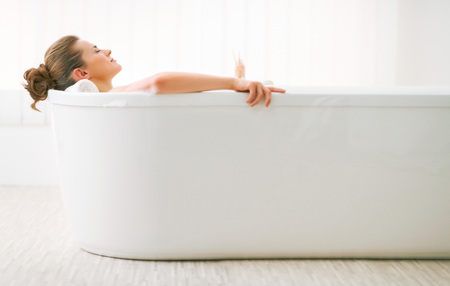 Relaxed young woman laying in bathtubの写真素材