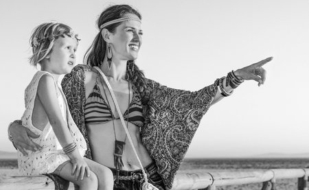 Bohemian vibe vacation. Full length portrait of happy boho mother and child outdoors in the summer...