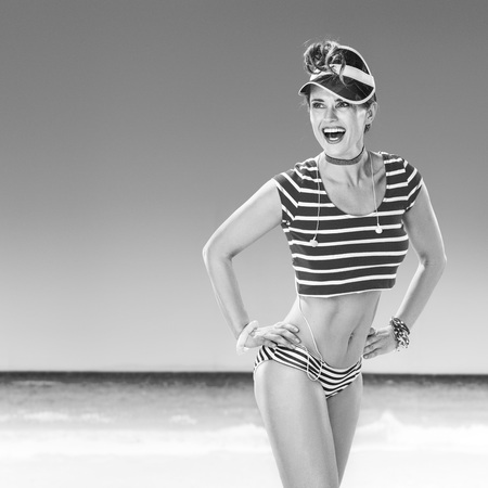 Perfect summer. smiling active woman  in red sun visor on the seacoast looking at copy spaceの写真素材