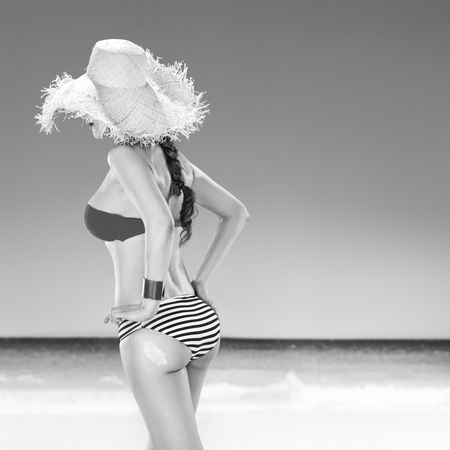 Perfect summer. healthy woman on the beach applying sun creamの写真素材